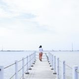 海を眺める女性の後ろ姿