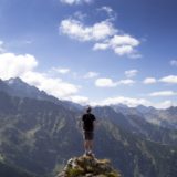 自信を持って丘に立つ男性の後ろ姿