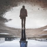 水たまりに反射する男性